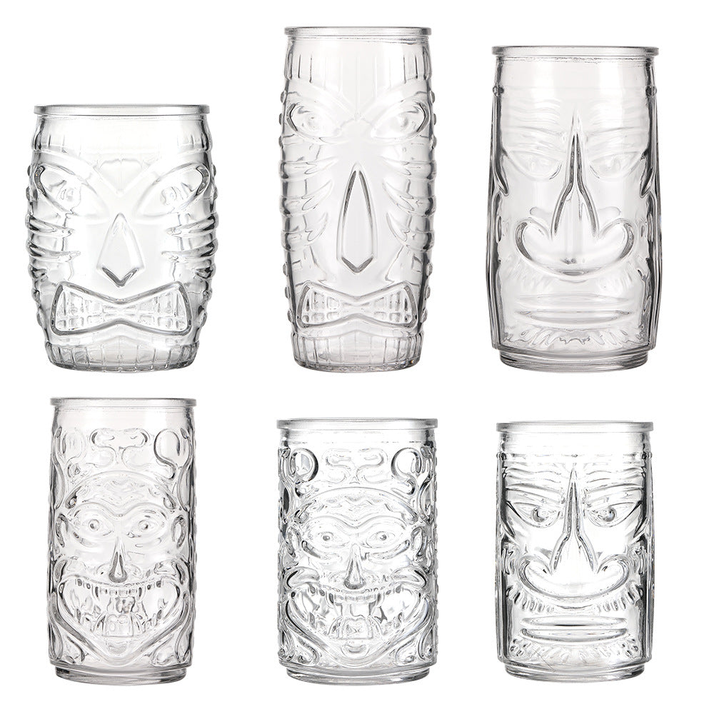 Transparent drinkware featuring unique embossed face designs in six cylindrical glass mugs.