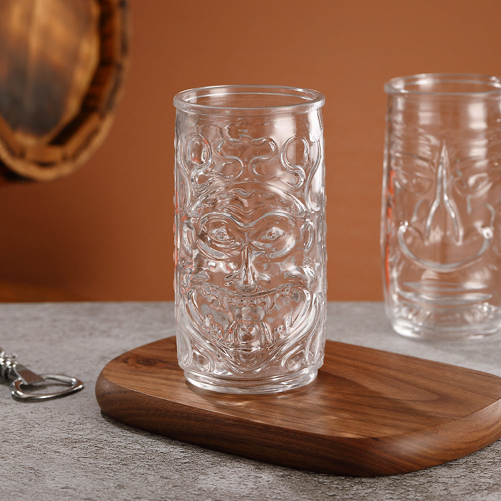 Transparent drinkware featuring unique embossed face designs in six cylindrical glass mugs.