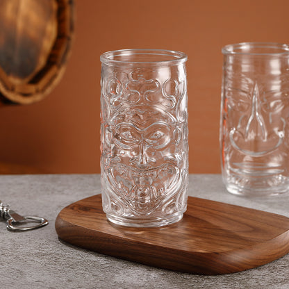 Transparent drinkware featuring unique embossed face designs in six cylindrical glass mugs.