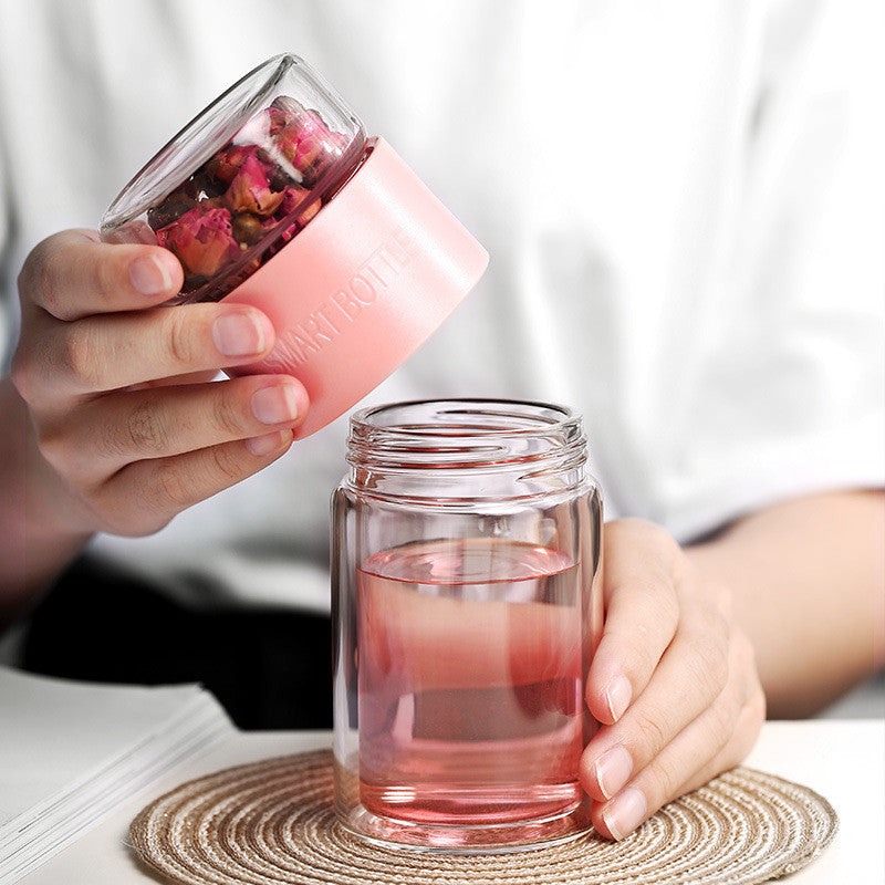 Portable travel drinkware set featuring high borosilicate glass tea tumbler and protective sleeve on a wooden table.