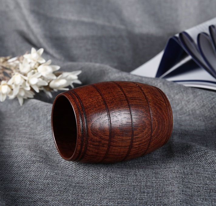 Wooden tea cup made of polished wood, featuring a barrel shape and a rich dark wood color, perfect for serving beverages.