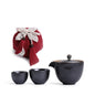 Portable teaware set featuring a teapot and two cups with a red carrying pouch for convenient tea on the go.