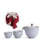 Portable teaware set featuring a teapot and two cups with a red carrying pouch for convenient tea on the go.