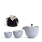 Portable teaware set featuring a teapot and two cups with a red carrying pouch for convenient tea on the go.