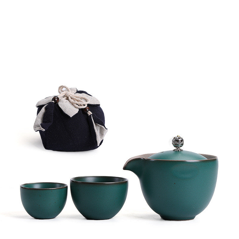 Portable teaware set featuring a teapot and two cups with a red carrying pouch for convenient tea on the go.