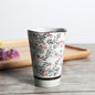 Japanese ceramic mug featuring a delicate flower pattern and elegant round shape on a wooden surface.