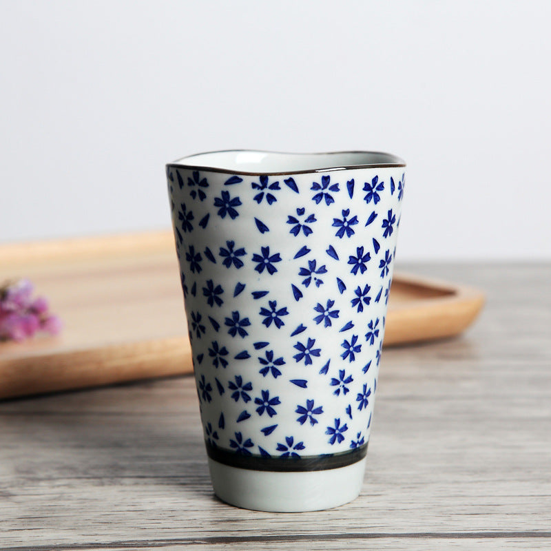 Japanese ceramic mug featuring a delicate flower pattern and elegant round shape on a wooden surface.