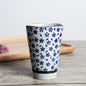 Japanese ceramic mug featuring a delicate flower pattern and elegant round shape on a wooden surface.