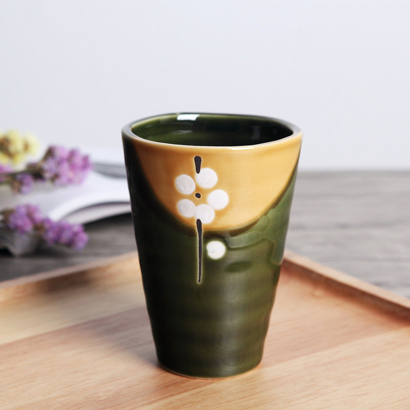 Japanese ceramic mug featuring a delicate flower pattern and elegant round shape on a wooden surface.