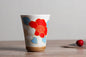 Japanese ceramic mug featuring a delicate flower pattern and elegant round shape on a wooden surface.