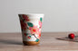 Japanese ceramic mug featuring a delicate flower pattern and elegant round shape on a wooden surface.