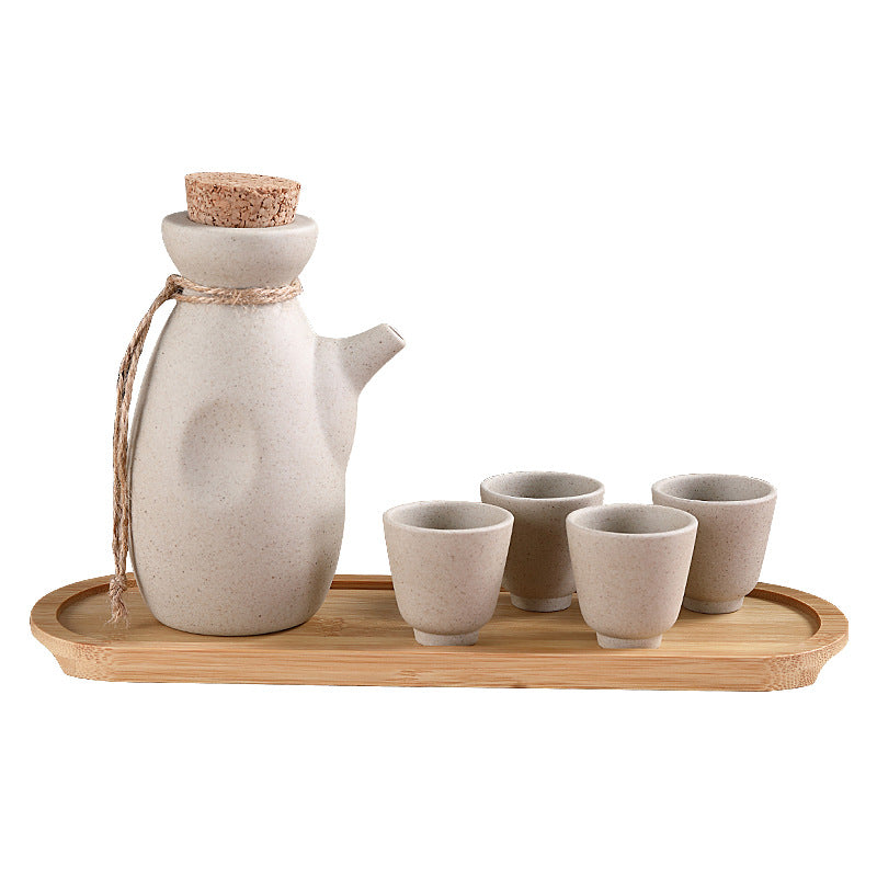 Japanese sake pot set displayed on a bamboo tray with four ceramic cups, perfect for traditional drinkware.