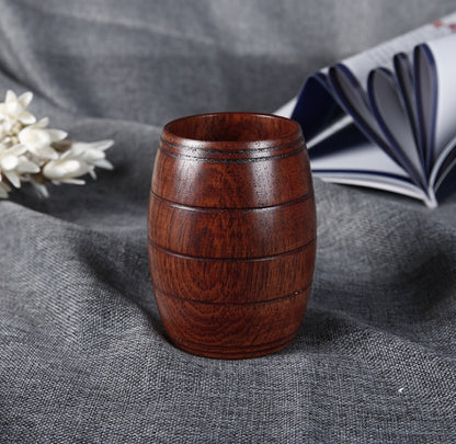 Wooden tea cup made of polished wood, featuring a barrel shape and a rich dark wood color, perfect for serving beverages.