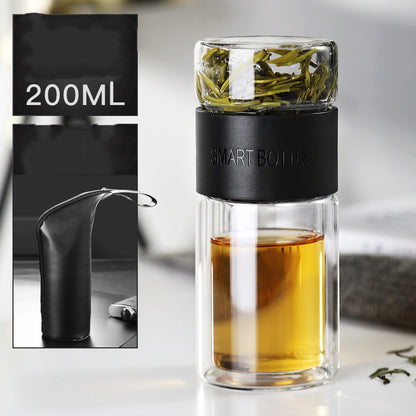 Portable travel drinkware set featuring high borosilicate glass tea tumbler and protective sleeve on a wooden table.