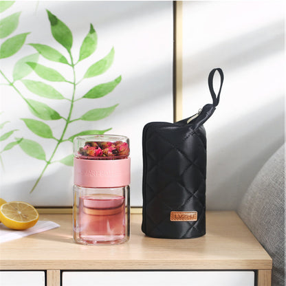 Portable travel drinkware set featuring high borosilicate glass tea tumbler and protective sleeve on a wooden table.