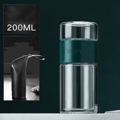 Portable travel drinkware set featuring high borosilicate glass tea tumbler and protective sleeve on a wooden table.