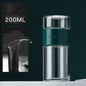 Portable travel drinkware set featuring high borosilicate glass tea tumbler and protective sleeve on a wooden table.