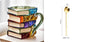 Book shaped glass mug featuring a colorful 3D design resembling a stack of illustrated books.