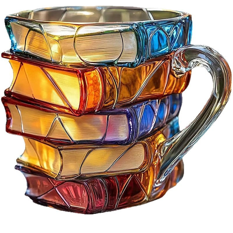 Book shaped glass mug featuring a colorful 3D design resembling a stack of illustrated books.