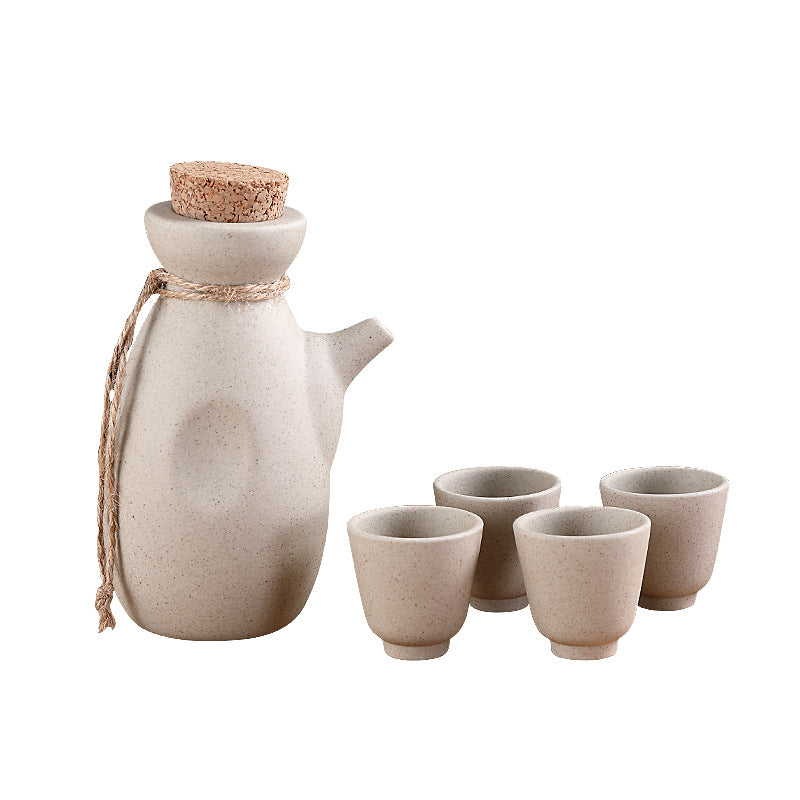 Japanese sake pot set displayed on a bamboo tray with four ceramic cups, perfect for traditional drinkware.